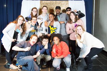Students pose at a photobooth in the ballroom