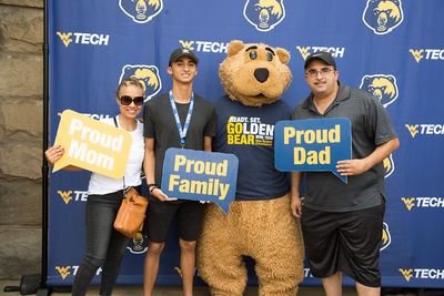 A family poses in front of a WVU Tech backdrop with Tech mascot Monty.